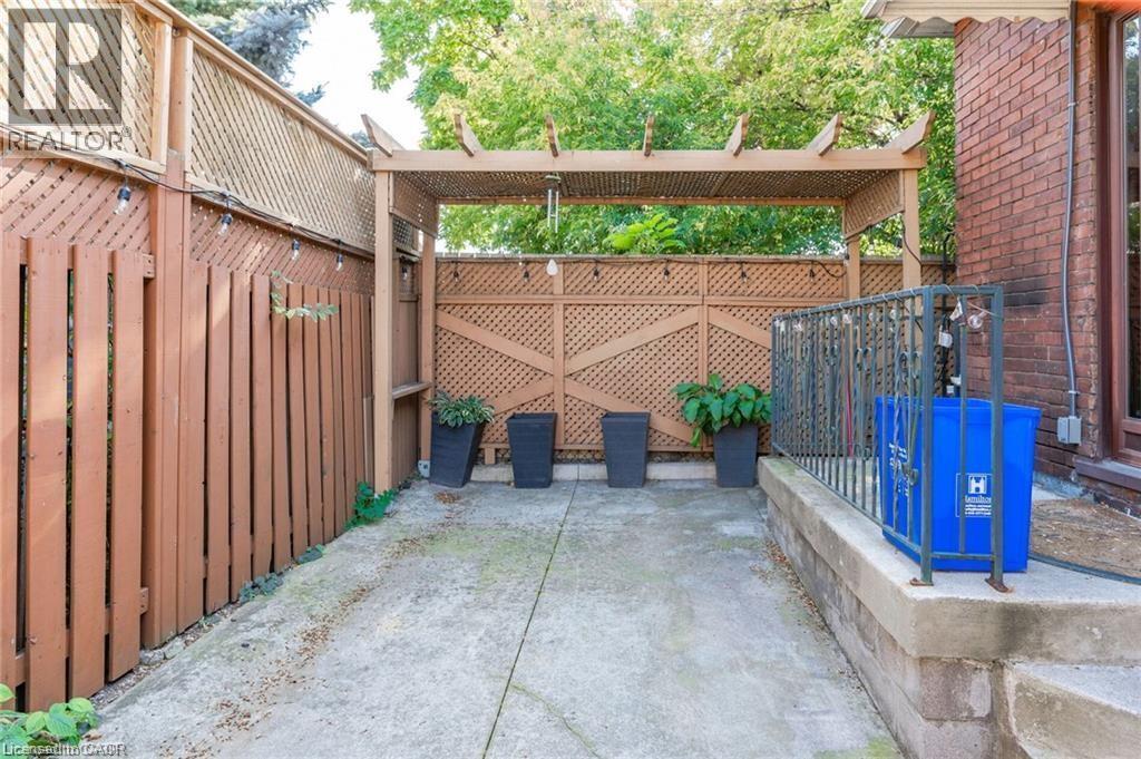 Outdoor patio area featuring a wooden pergola and lattice fencing - 252 Beechwood Avenue, Hamilton, ON - Outdoor With Exterior