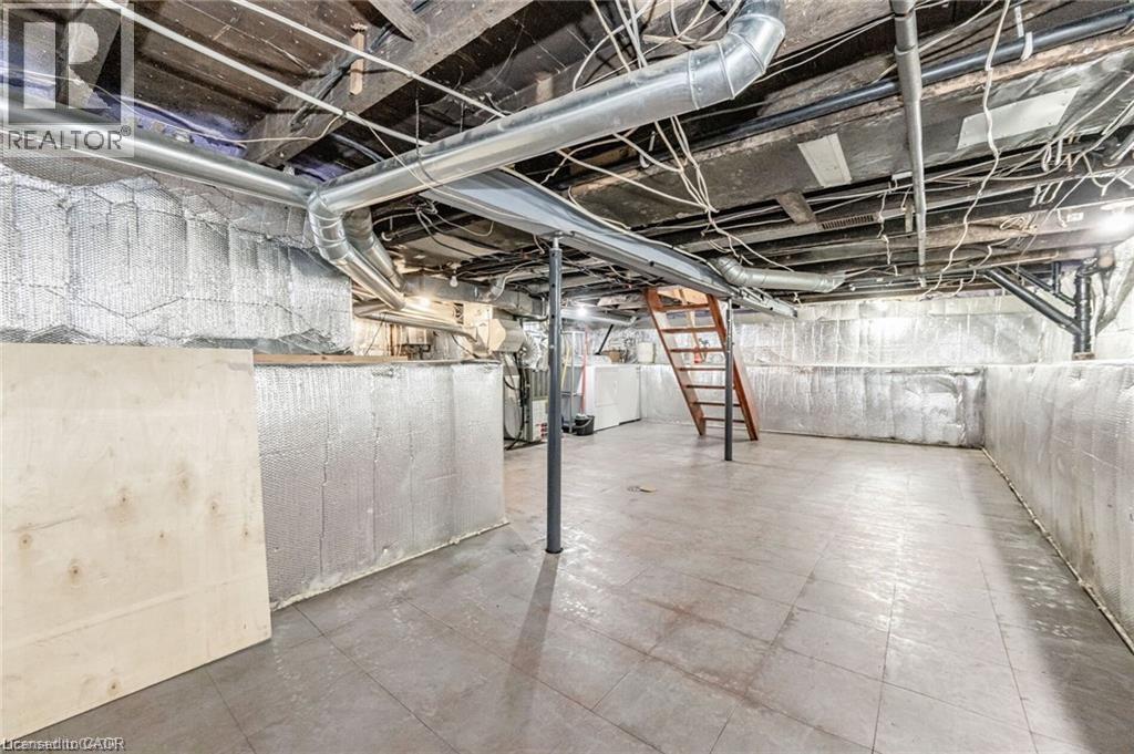 Basement featuring exposed ceiling joists, overhead ductwork, and a wooden staircase - 252 Beechwood Avenue, Hamilton, ON - Indoor Photo Showing Basement