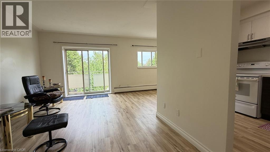 Living area featuring wood-finish flooring, light-colored walls, and a large sliding glass door - 206 Indian Road, Kitchener, ON - Indoor