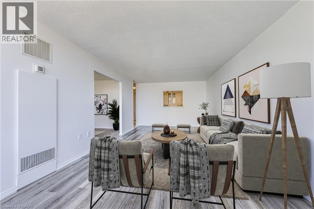 Open-concept living space featuring light wood-finish flooring, white walls, and a pass-through window - 1270 Maple Crossing Boulevard Unit# 1705, Burlington, ON - Indoor Photo Showing Dining Room