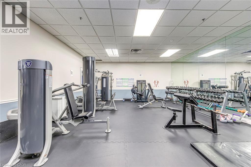 Fitness center featuring a variety of exercise equipment, mirrored wall, and recessed lighting - 1270 Maple Crossing Boulevard Unit# 1705, Burlington, ON - Indoor Photo Showing Gym Room