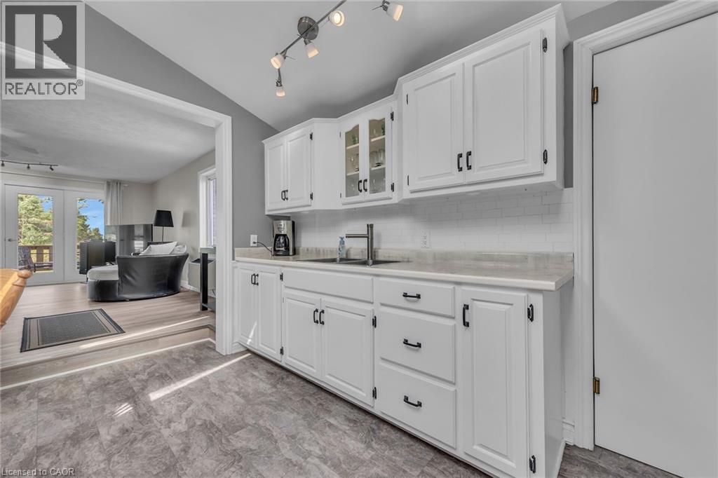 Kitchen featuring white cabinetry with black hardware, a subway tile backsplash, and light-toned countertops - 270 Erie Boulevard, Long Point, ON - Indoor