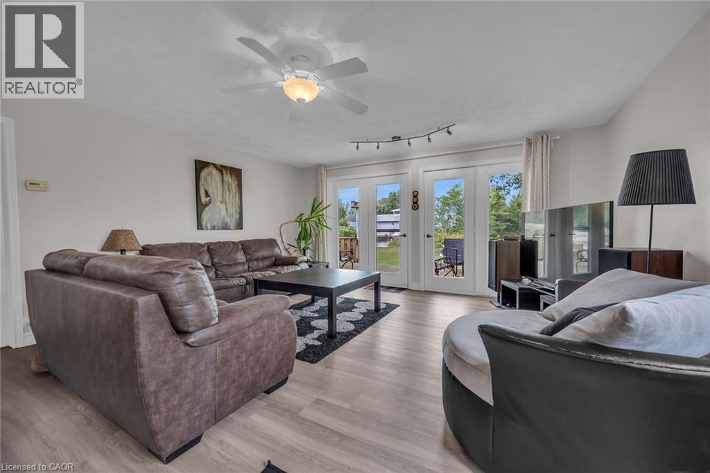 Living area featuring light wood-finish flooring and a ceiling fan with integrated lighting - 270 Erie Boulevard, Long Point, ON - Indoor Photo Showing Living Room