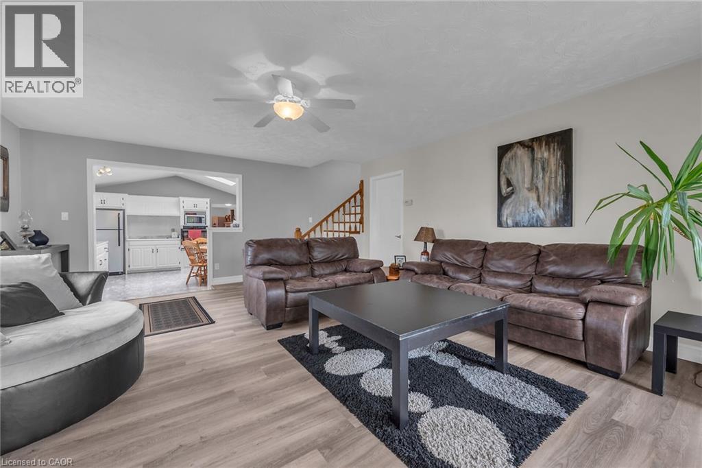 Spacious living area featuring wood-finish flooring, light gray walls, and a ceiling fan with integrated lighting - 270 Erie Boulevard, Long Point, ON - Indoor Photo Showing Living Room