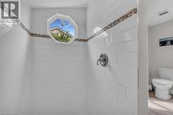 Shower with white subway tile, a decorative mosaic tile accent band, and a chrome shower fixture -