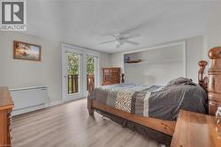 Room featuring light wood-finish flooring, a ceiling fan, and white walls -