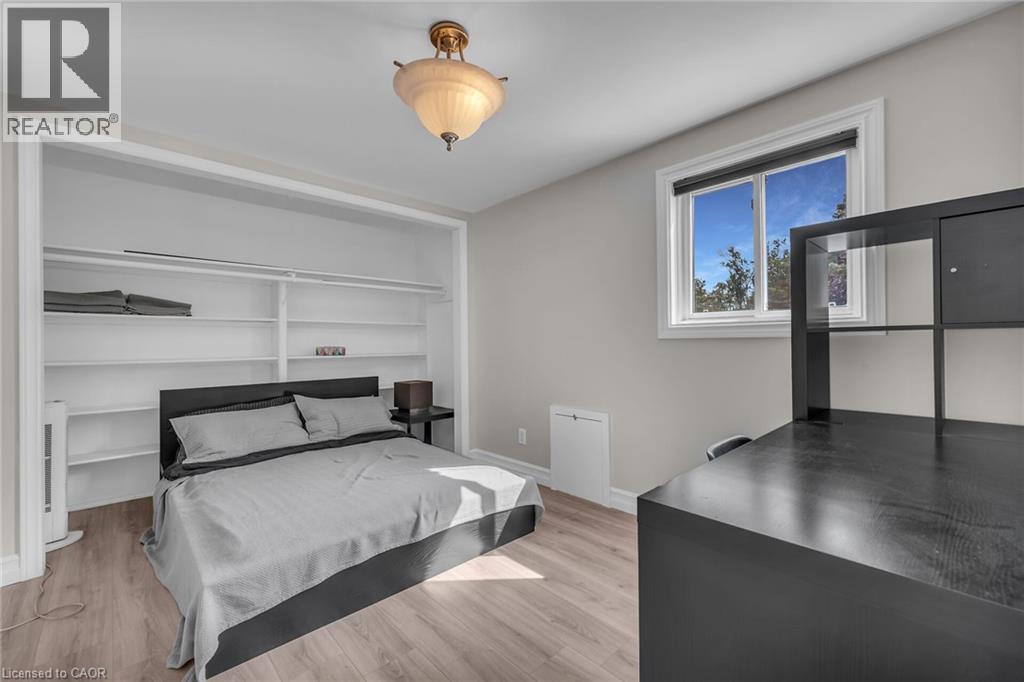 Recessed built-in shelving, wood-finish flooring, and a contemporary light fixture - 270 Erie Boulevard, Long Point, ON - Indoor Photo Showing Bedroom
