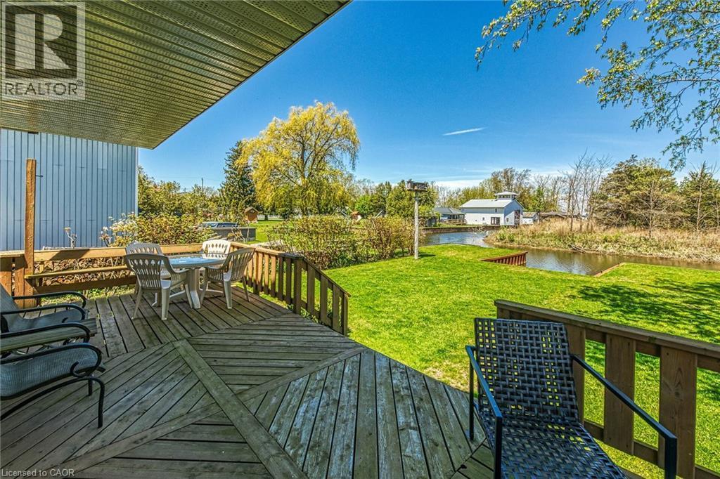 Expansive wood deck with geometric pattern, featuring a railing system and covered porch area - 270 Erie Boulevard, Long Point, ON - Outdoor With Deck Patio Veranda