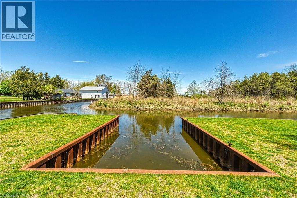 Waterfront property featuring a private boat slip with metal retaining walls - 270 Erie Boulevard, Long Point, ON - Outdoor With Body Of Water