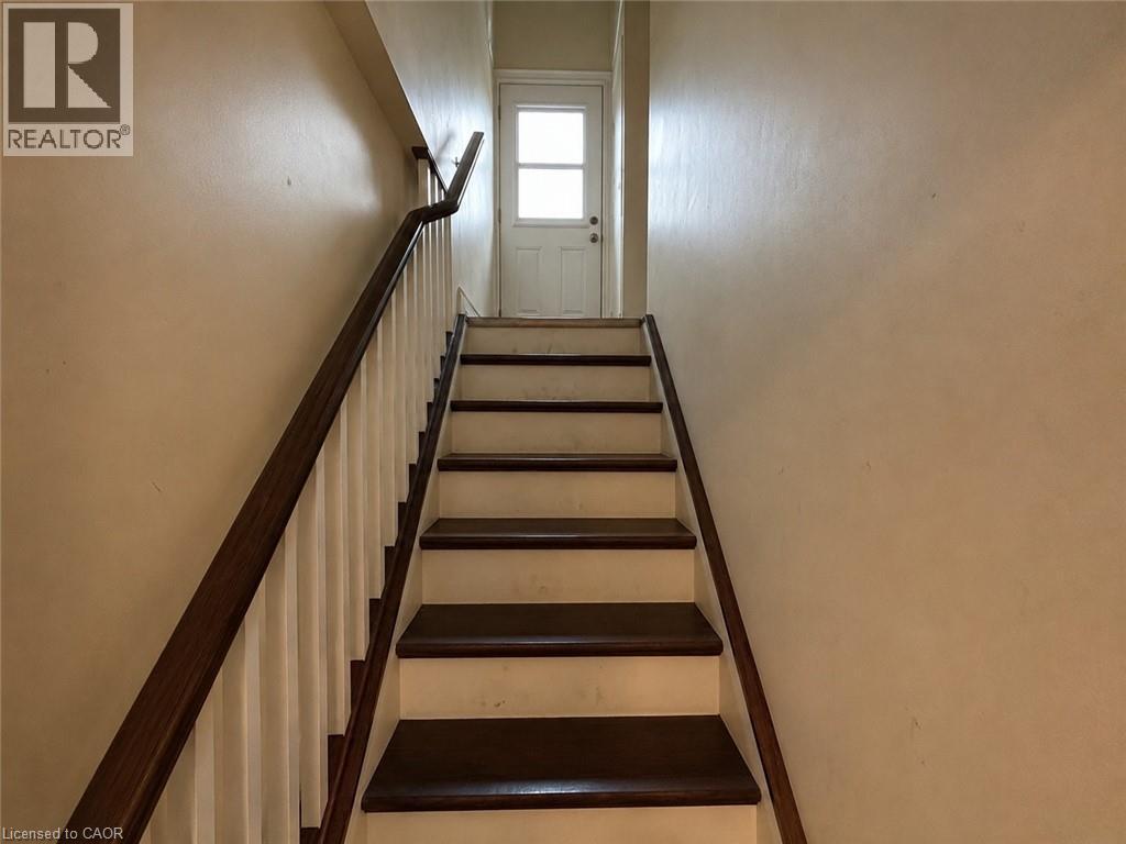 Staircase featuring dark wood-finish treads and handrail, white risers, and white balusters - 917 Orpha Street, Burlington, ON - Indoor Photo Showing Other Room