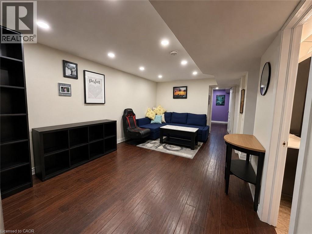 Open-concept living area featuring rich wood-finish flooring, recessed lighting, and neutral wall tones - 917 Orpha Street, Burlington, ON - Indoor