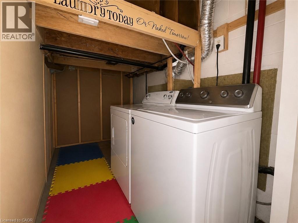 Dedicated laundry area featuring white top-load appliances, exposed wood beams, and a finished wall - 917 Orpha Street, Burlington, ON - Indoor Photo Showing Laundry Room