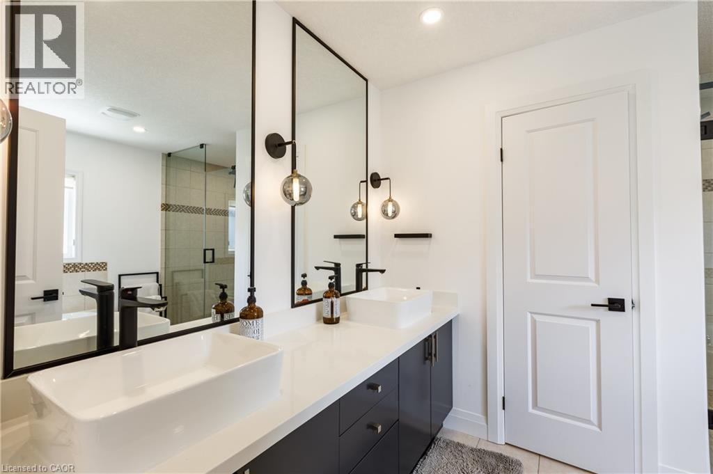 Bathroom featuring a dual vanity with rectangular vessel sinks, matte black faucets, and black framed mirrors - 916 Steepleridge Court, Kitchener, ON - Indoor Photo Showing Bathroom
