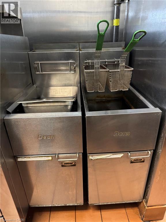 Stainless steel commercial fryers with integrated baskets and a stainless steel backsplash - 255 King Street N, Waterloo, ON