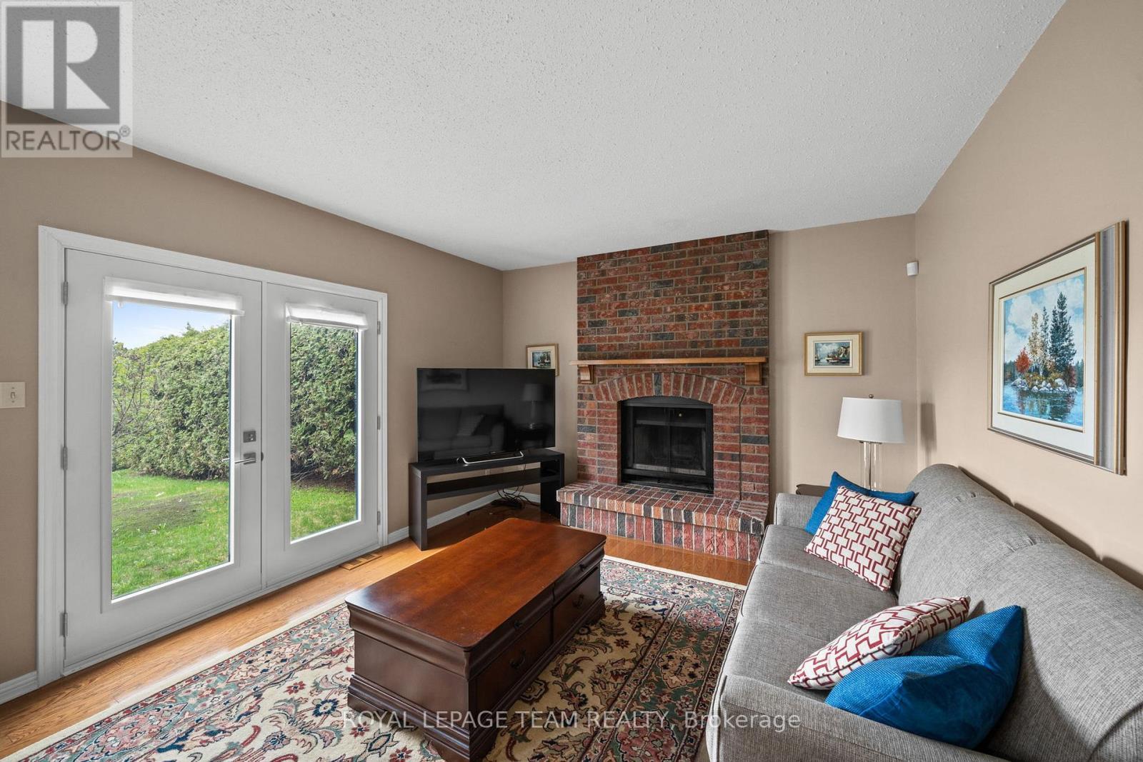 Sunken Den/Living Room with w/o to backyard - 28 Parmalea Crescent, Ottawa, ON - Indoor Photo Showing Living Room With Fireplace