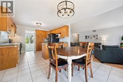Open-concept kitchen featuring wood cabinetry, tile flooring, and integrated appliances -