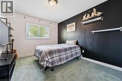 Room featuring light green carpeting and a prominent dark accent wall -