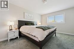 Room featuring light-colored walls and grey carpeting -