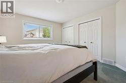 Room featuring light neutral wall paint, a window with blinds, two bi-fold closet doors with paneling, baseboard trim, and carpet flooring -