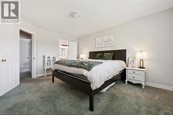 Spacious bedroom featuring light neutral wall tones, soft carpet flooring, and white trim -