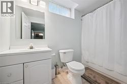 Bathroom featuring a vanity with integrated sink, rectangular mirror, and three-light fixture -