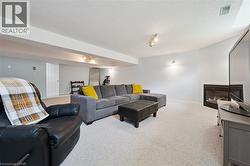 Carpeted living space featuring recessed lighting, track lighting, and wall sconces -