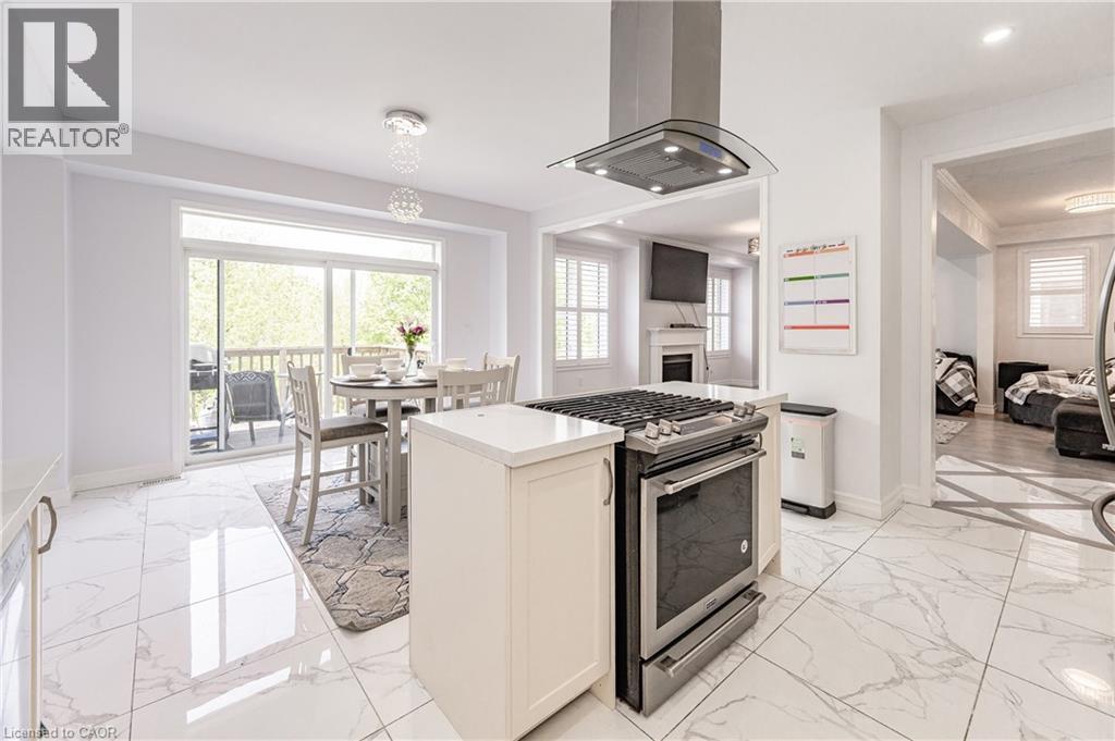 Contemporary kitchen featuring stainless steel appliances, white cabinetry, and large format marble-look tile flooring - 9 Fleming Crescent, Caledonia, ON - Indoor Photo Showing Other Room
