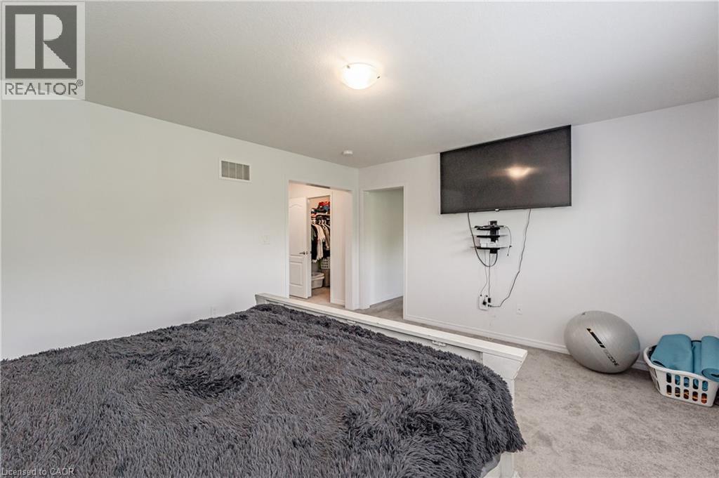 Carpeted room featuring a ceiling-mounted light fixture and a wall-mounted television - 9 Fleming Crescent, Caledonia, ON - Indoor Photo Showing Bedroom
