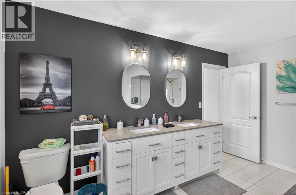 Dual vanity with white cabinetry, light countertops, and integrated sinks - 9 Fleming Crescent, Caledonia, ON - Indoor Photo Showing Bathroom