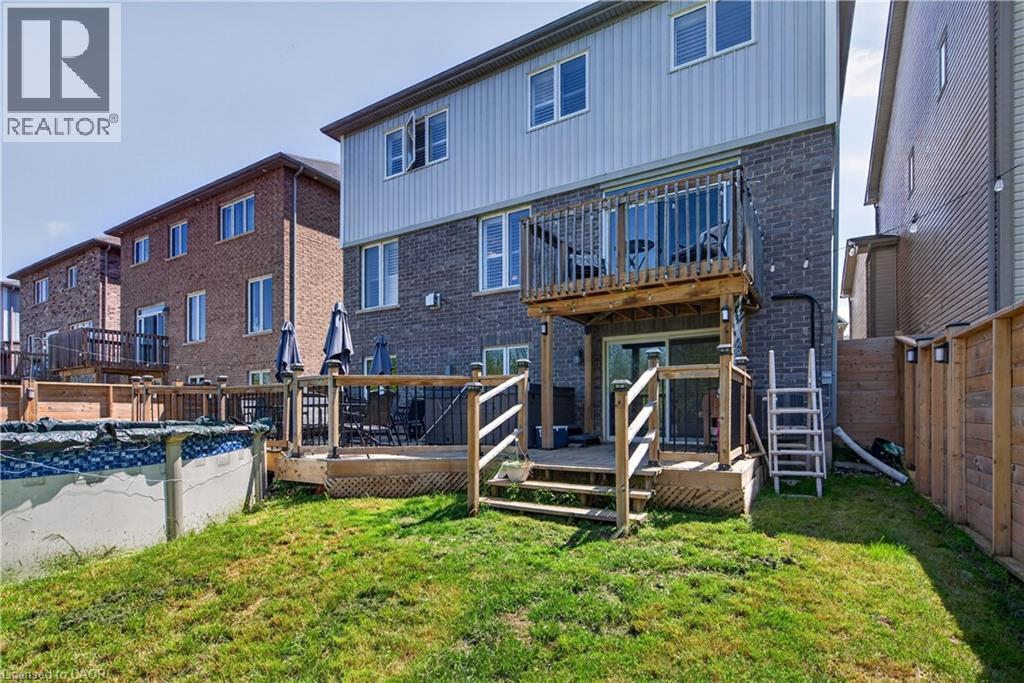 Rear exterior featuring a multi-level wood deck, a second-story balcony with wood railings, and a ground-level patio - 9 Fleming Crescent, Caledonia, ON - Outdoor With Deck Patio Veranda