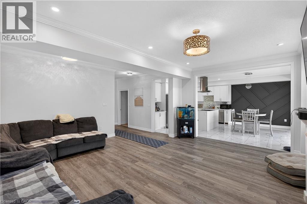 Open-concept living area with wood-finish flooring, recessed lighting, and crown molding - 9 Fleming Crescent, Caledonia, ON - Indoor