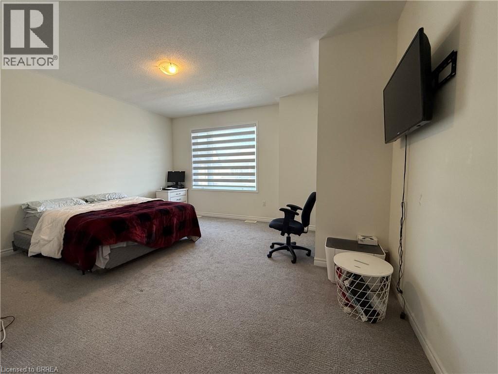 Carpeted interior space featuring a window with horizontal blinds, a wall-mounted television, and a flush-mount ceiling light fixture - 18 Dolucci Crescent, Brampton, ON - Indoor Photo Showing Bedroom