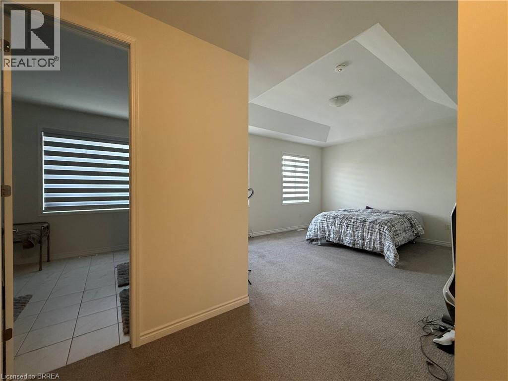 Spacious room with a tray ceiling and light-colored carpeting - 18 Dolucci Crescent, Brampton, ON - Indoor Photo Showing Bedroom