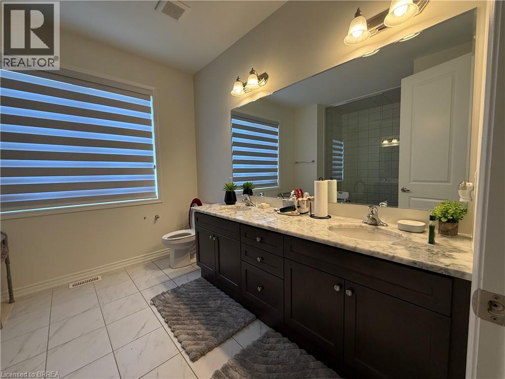 Double vanity featuring dark wood-finish cabinetry and a light-toned countertop - 18 Dolucci Crescent, Brampton, ON - Indoor Photo Showing Bathroom