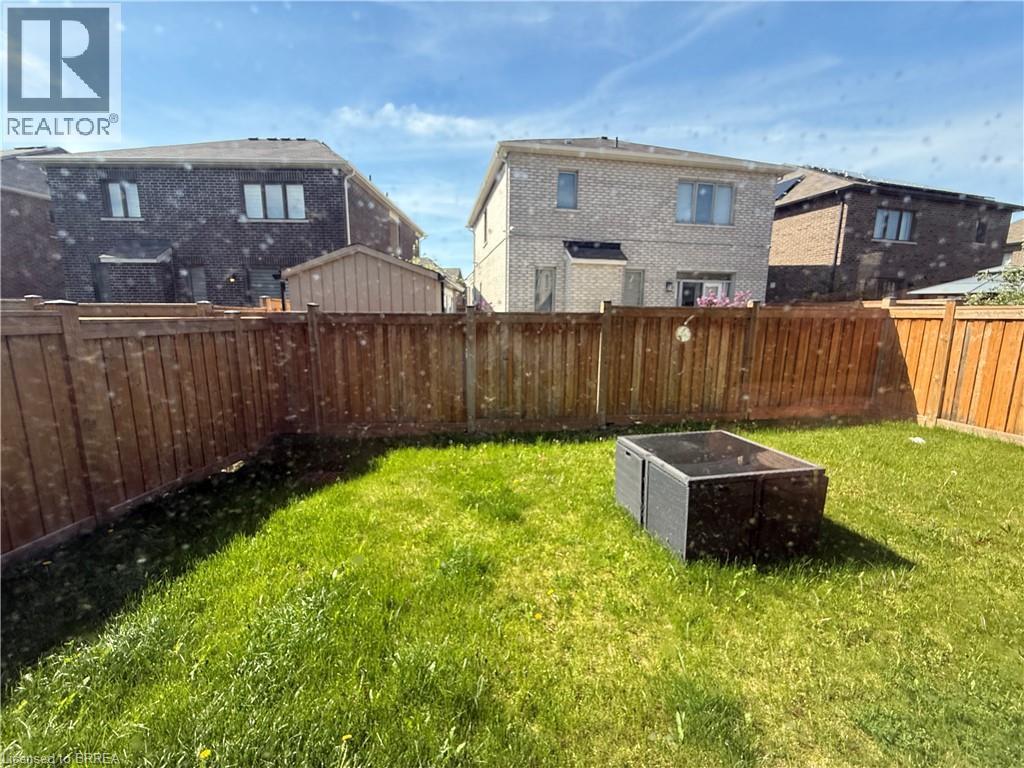 Expansive green lawn with a perimeter wood fence, offering privacy - 18 Dolucci Crescent, Brampton, ON - Outdoor