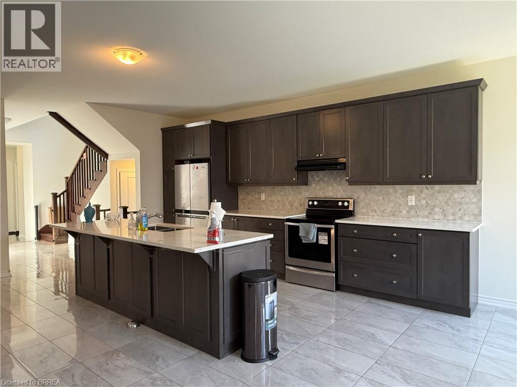 Kitchen featuring dark wood-finish cabinetry, light-toned countertops, and a mosaic tile backsplash - 18 Dolucci Crescent, Brampton, ON - Indoor Photo Showing Kitchen With Double Sink