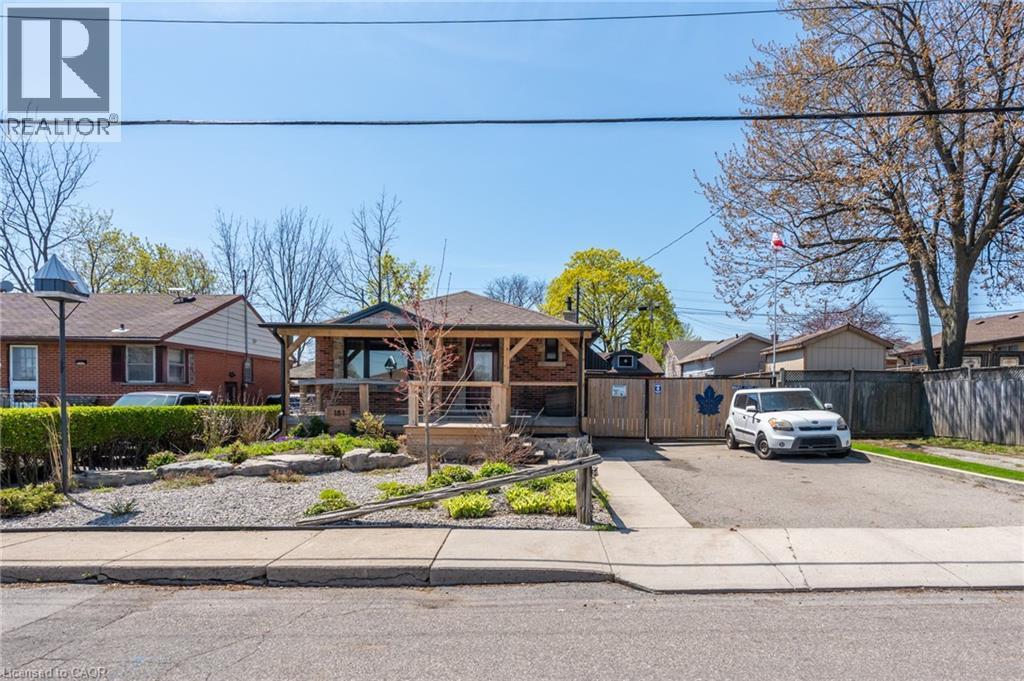 Brick facade residence with a covered front porch featuring wood-look posts and a stone base - 151 Winchester Boulevard, Hamilton, ON - Outdoor With Facade