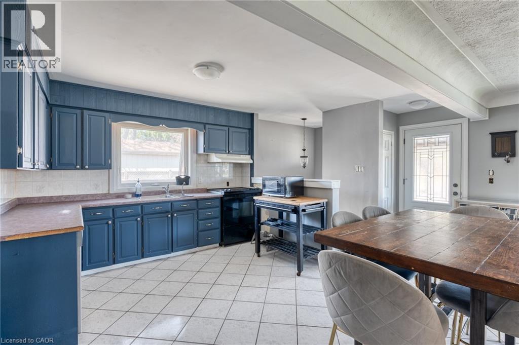 Kitchen featuring blue cabinetry, white tile flooring, a built-in range, and a window with natural light - 151 Winchester Boulevard, Hamilton, ON - Indoor