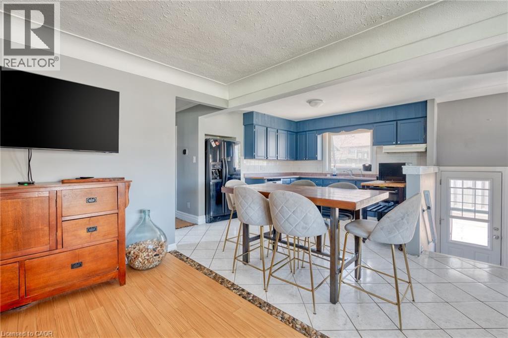 Open-concept kitchen with blue cabinetry and white tile flooring - 151 Winchester Boulevard, Hamilton, ON - Indoor Photo Showing Dining Room