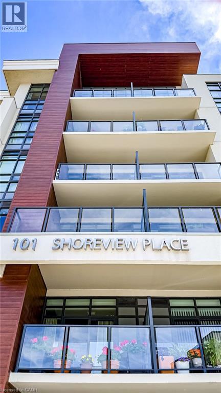 Modern multi-story building facade featuring wood-finish siding accents - 101 Shoreview Place Unit# 631, Stoney Creek, ON - Photo Showing Garage