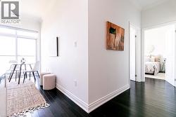 Dark wood-finish flooring throughout, white baseboards, and bright white walls -