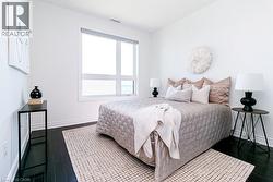 Bright room featuring a large picture window, dark wood-finish flooring, white baseboards, and white walls -