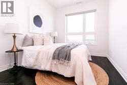 Bright interior featuring dark wood-finish flooring and a large window -