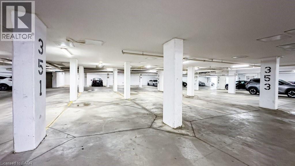 Underground parking facility featuring concrete flooring and structural pillars - 101 Shoreview Place Unit# 631, Stoney Creek, ON - Indoor Photo Showing Garage