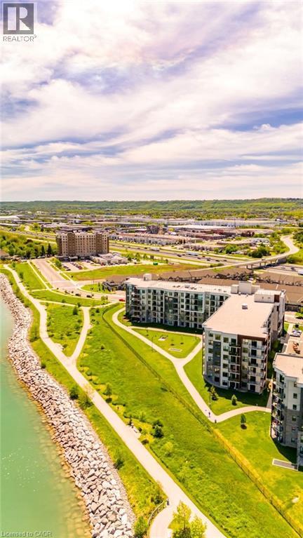 Modern multifamily residential buildings with balconies, bordering a body of water with a rock-lined shore - 101 Shoreview Place Unit# 631, Stoney Creek, ON - Outdoor With Body Of Water With View