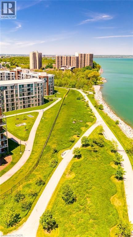 Aerial perspective showcasing contemporary multi-story buildings, expansive green spaces, and a prominent waterfront - 101 Shoreview Place Unit# 631, Stoney Creek, ON - Outdoor With Body Of Water With View