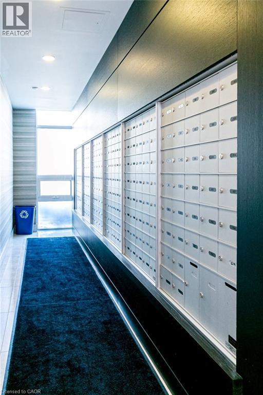 Mailroom featuring multiple rows of individual mailboxes, recessed lighting, and a dark wood-finish accent wall - 101 Shoreview Place Unit# 631, Stoney Creek, ON - Indoor Photo Showing Other Room