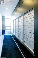 Mailroom featuring multiple rows of individual mailboxes, recessed lighting, and a dark wood-finish accent wall -