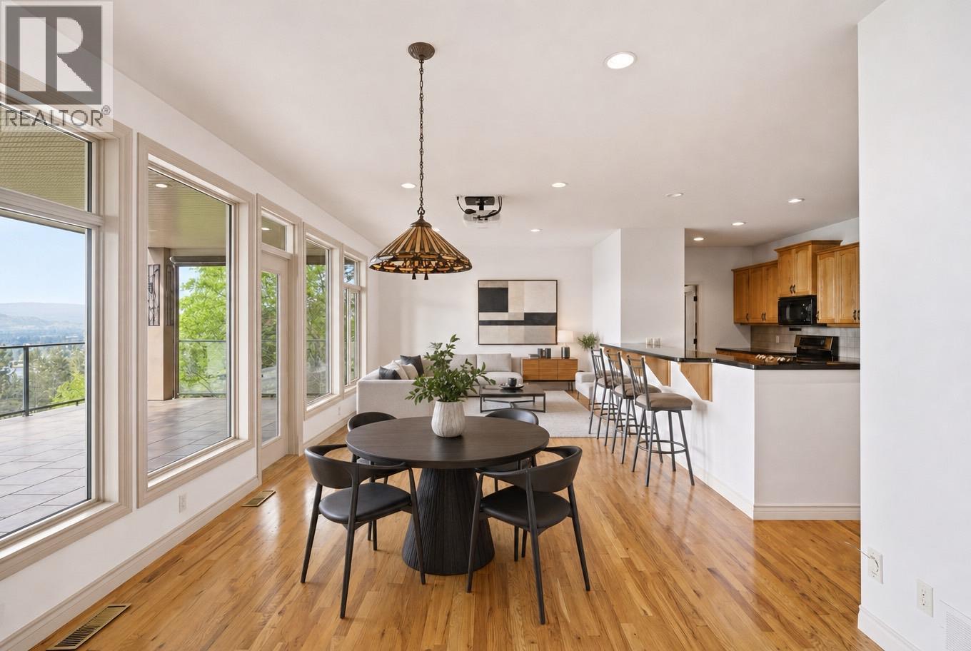 breakfast table and living room furniture are virtually staged - 448 Viewcrest Road, Kelowna, BC - Indoor Photo Showing Dining Room
