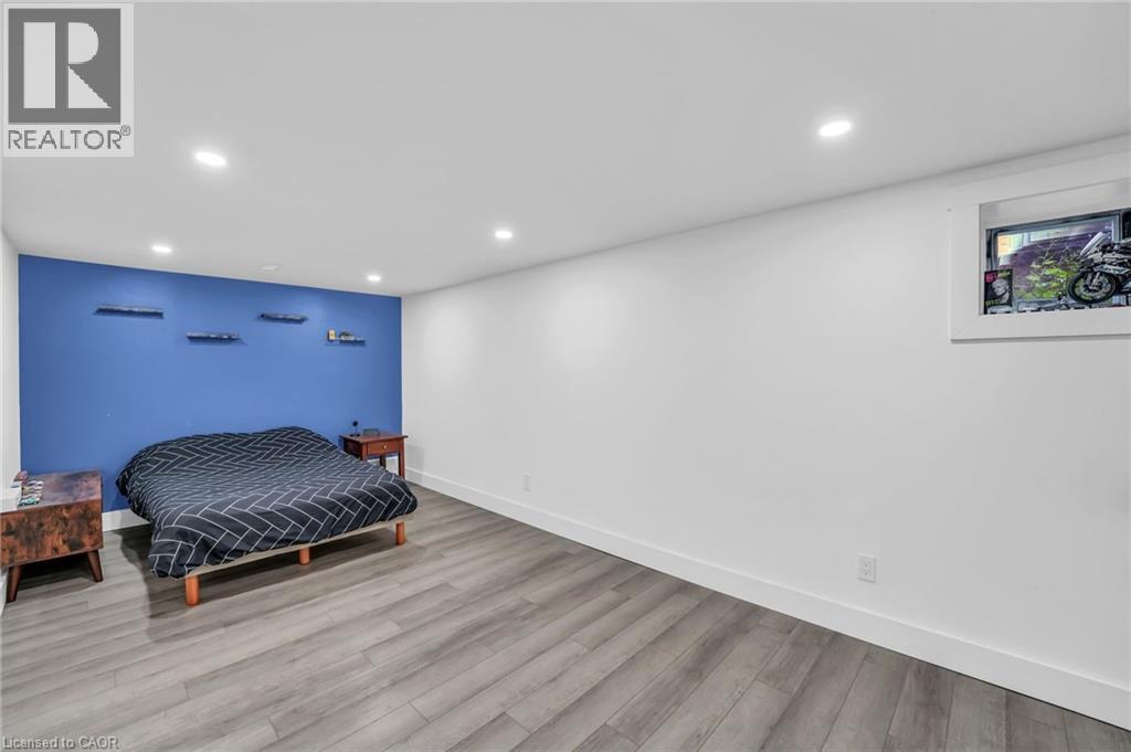 Room featuring wood-finish flooring, recessed lighting, and a window with a white frame - 25 Park Street E, Hamilton, ON - Indoor